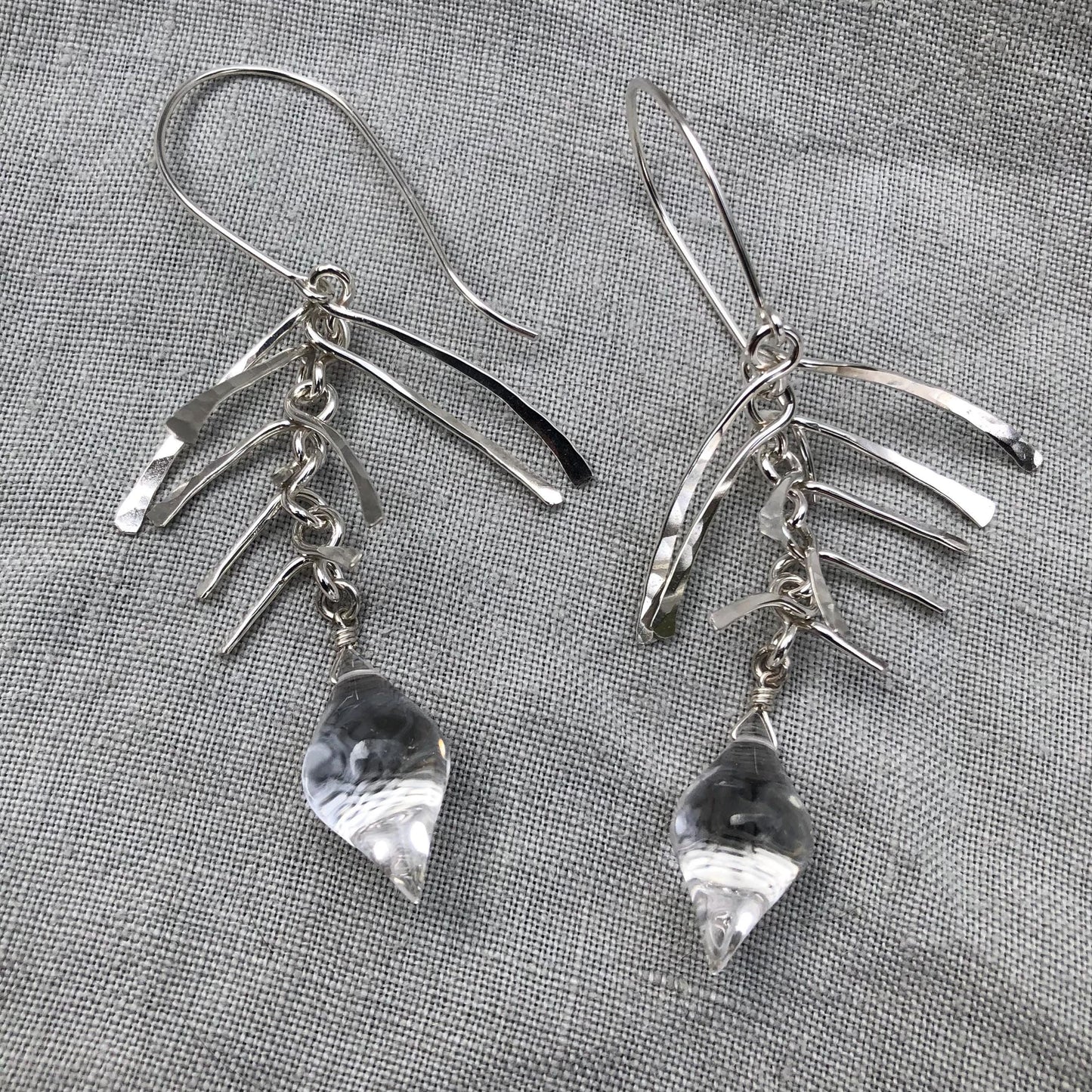 Kinetic sculptural earrings in hammered argentium sterling silver with clear quartz // Fishbone statement earrings with natural rock crystal
