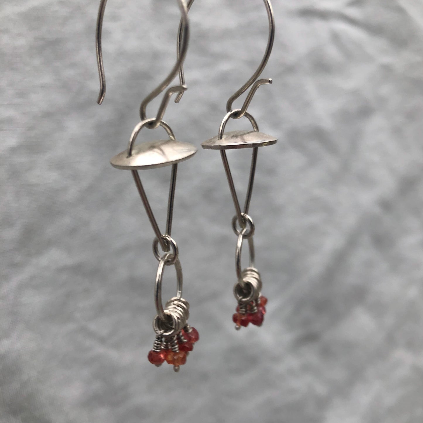 Red-orange sapphire kinetic chandelier earrings in argentium sterling silver