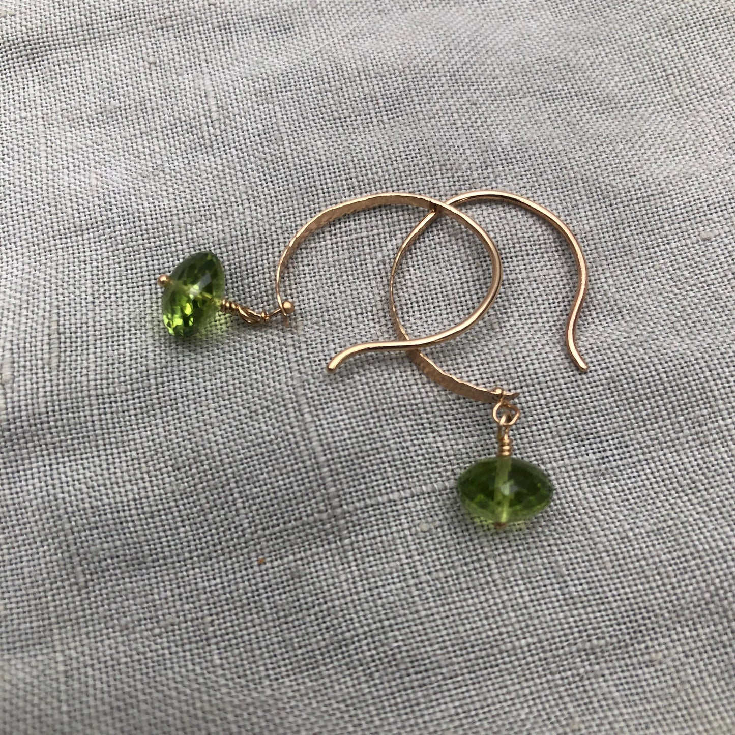Solid gold hoop earrings with faceted peridot drops