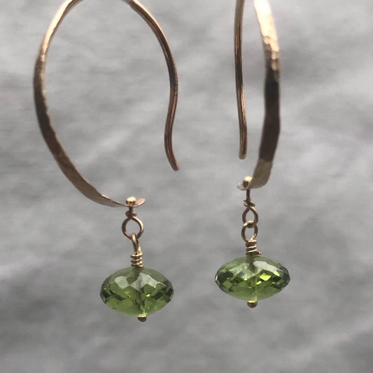 Solid gold hoop earrings with faceted peridot drops