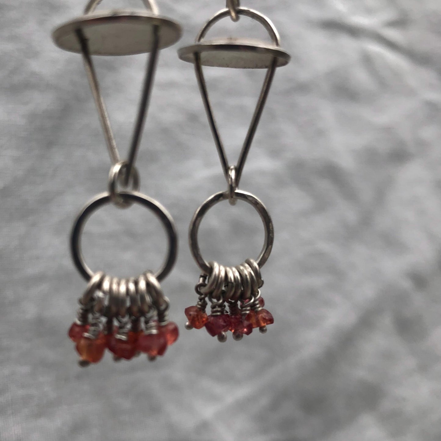 Red-orange sapphire kinetic chandelier earrings in argentium sterling silver