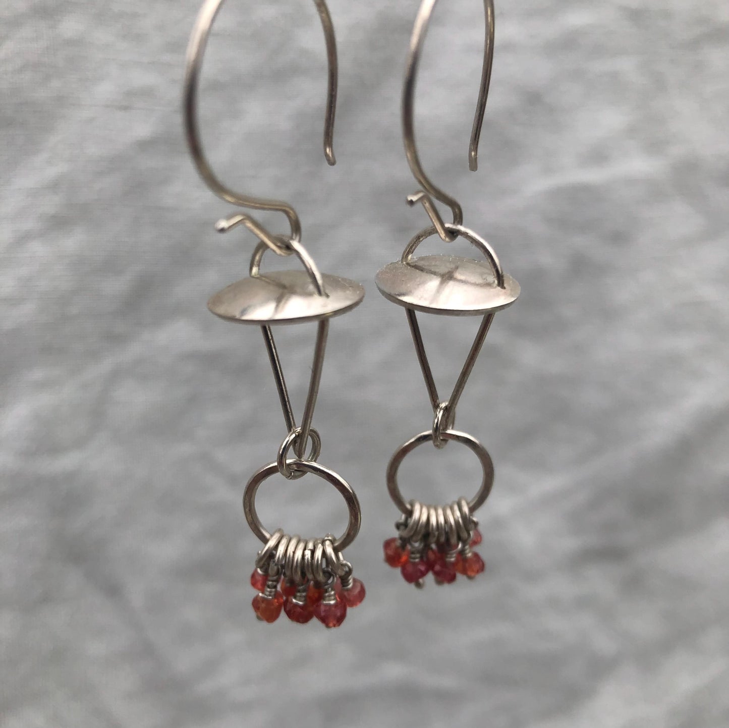 Red-orange sapphire kinetic chandelier earrings in argentium sterling silver