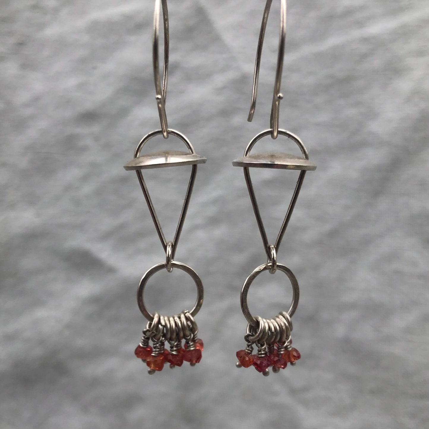 Red-orange sapphire kinetic chandelier earrings in argentium sterling silver