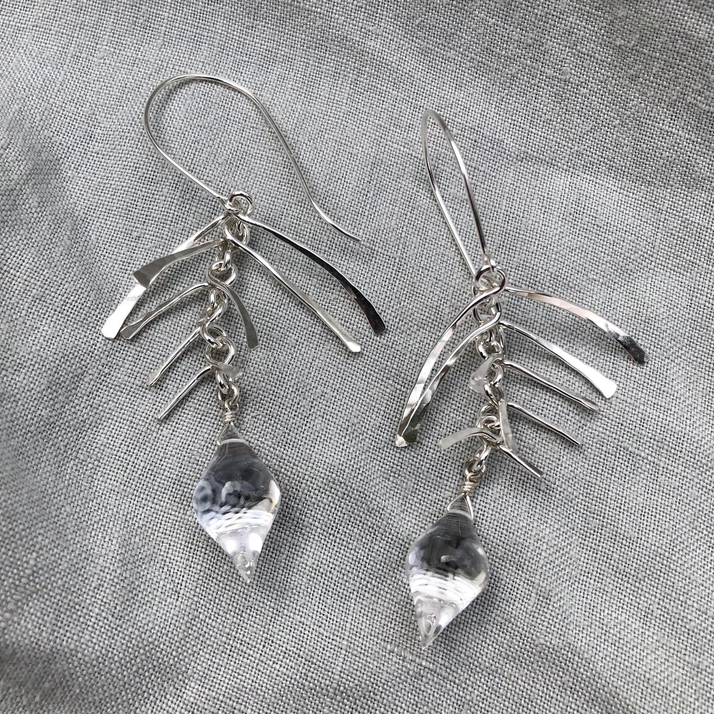 Kinetic sculptural earrings in hammered argentium sterling silver with clear quartz // Fishbone statement earrings with natural rock crystal