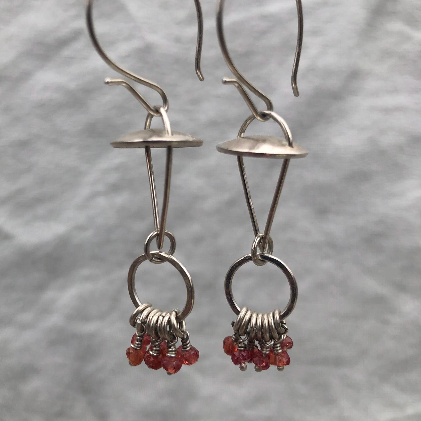 Red-orange sapphire kinetic chandelier earrings in argentium sterling silver