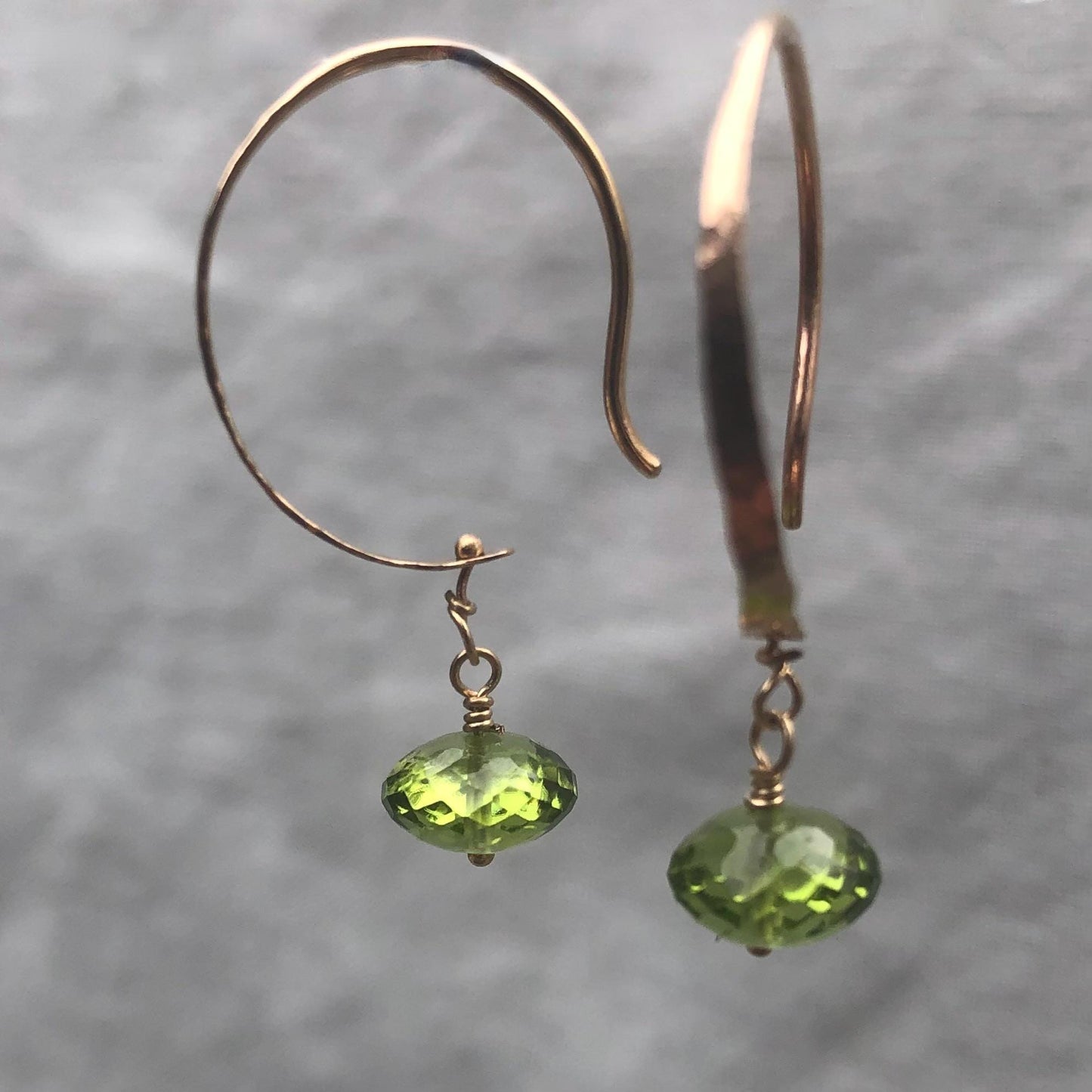 Solid gold hoop earrings with faceted peridot drops