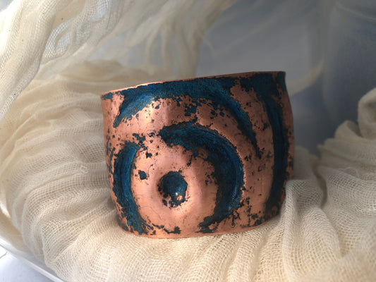 Eye cuff in chased and repoussé copper with blue patina