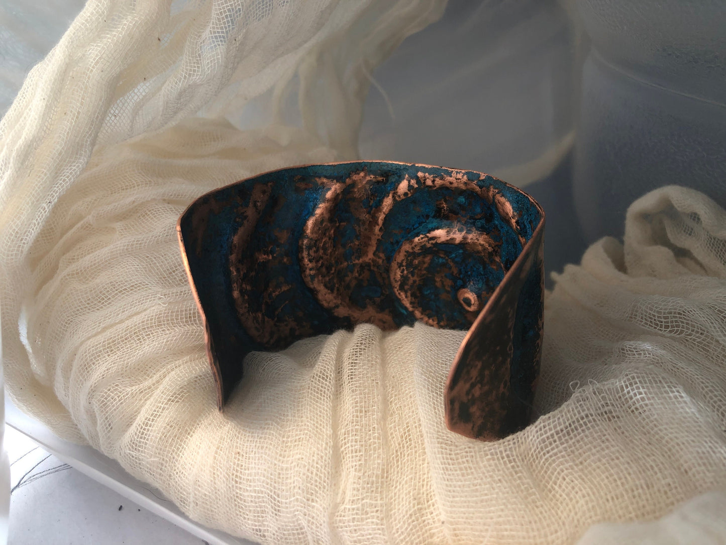 Eye cuff in chased and repoussé copper with blue patina