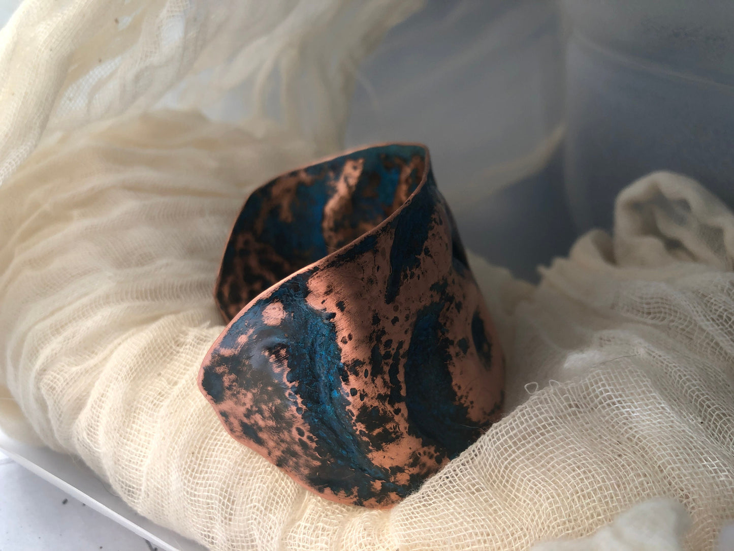 Eye cuff in chased and repoussé copper with blue patina