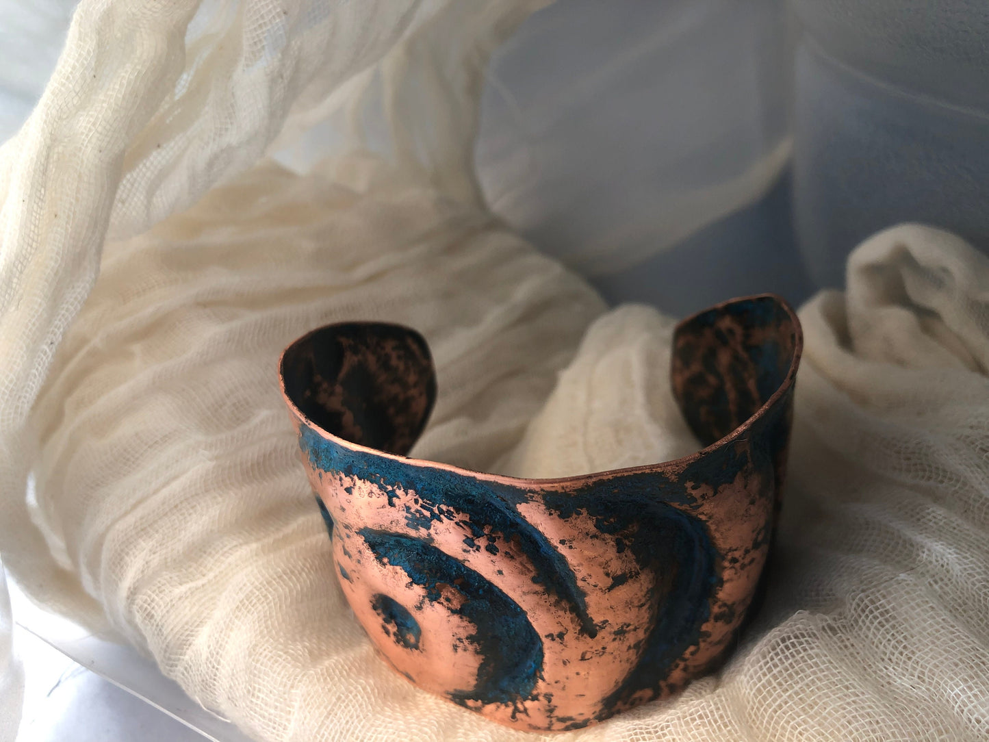 Eye cuff in chased and repoussé copper with blue patina