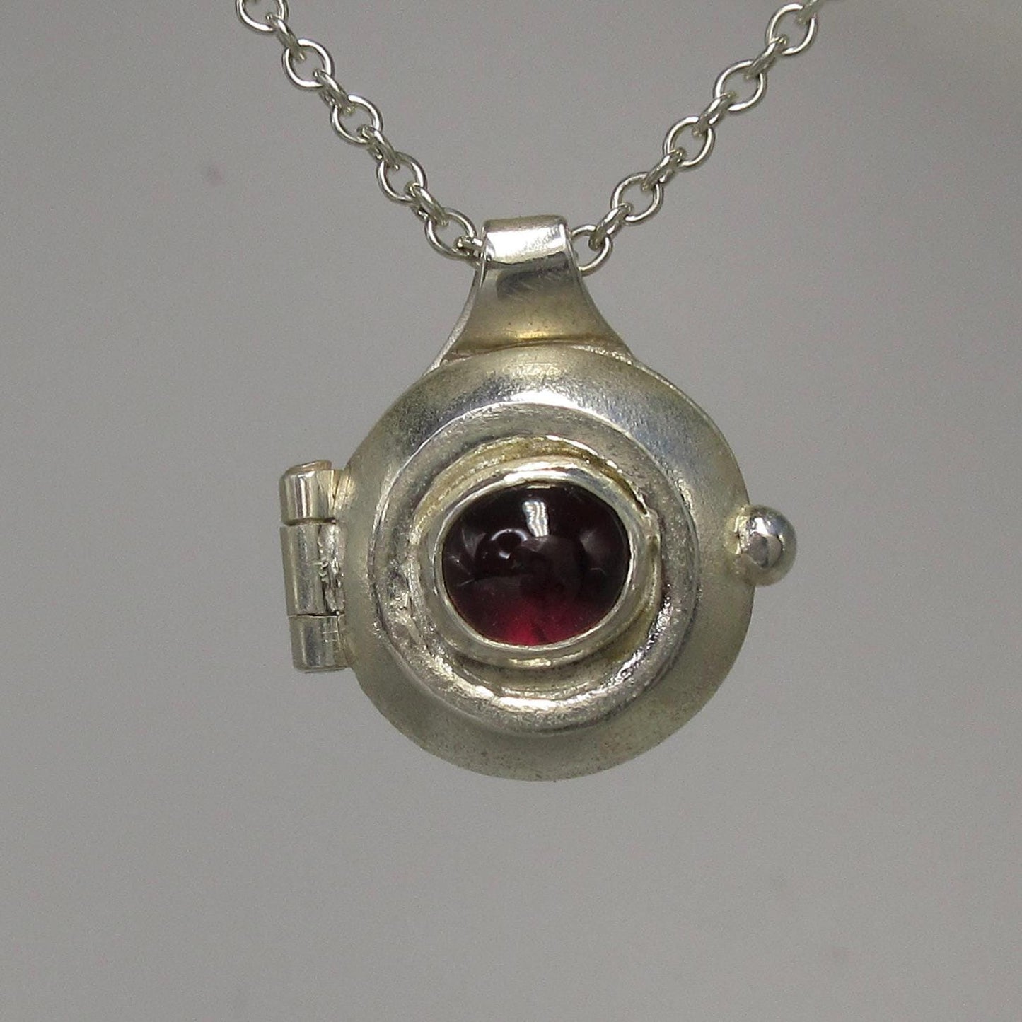 Garnet porthole locket in argentium sterling silver