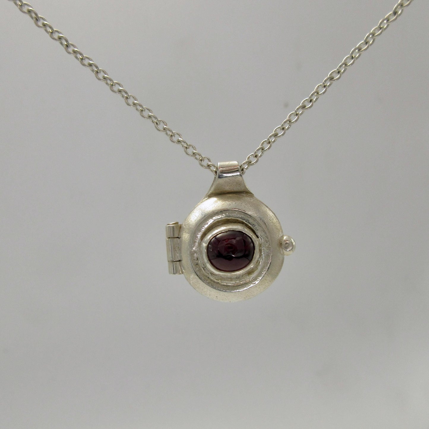 Garnet porthole locket in argentium sterling silver