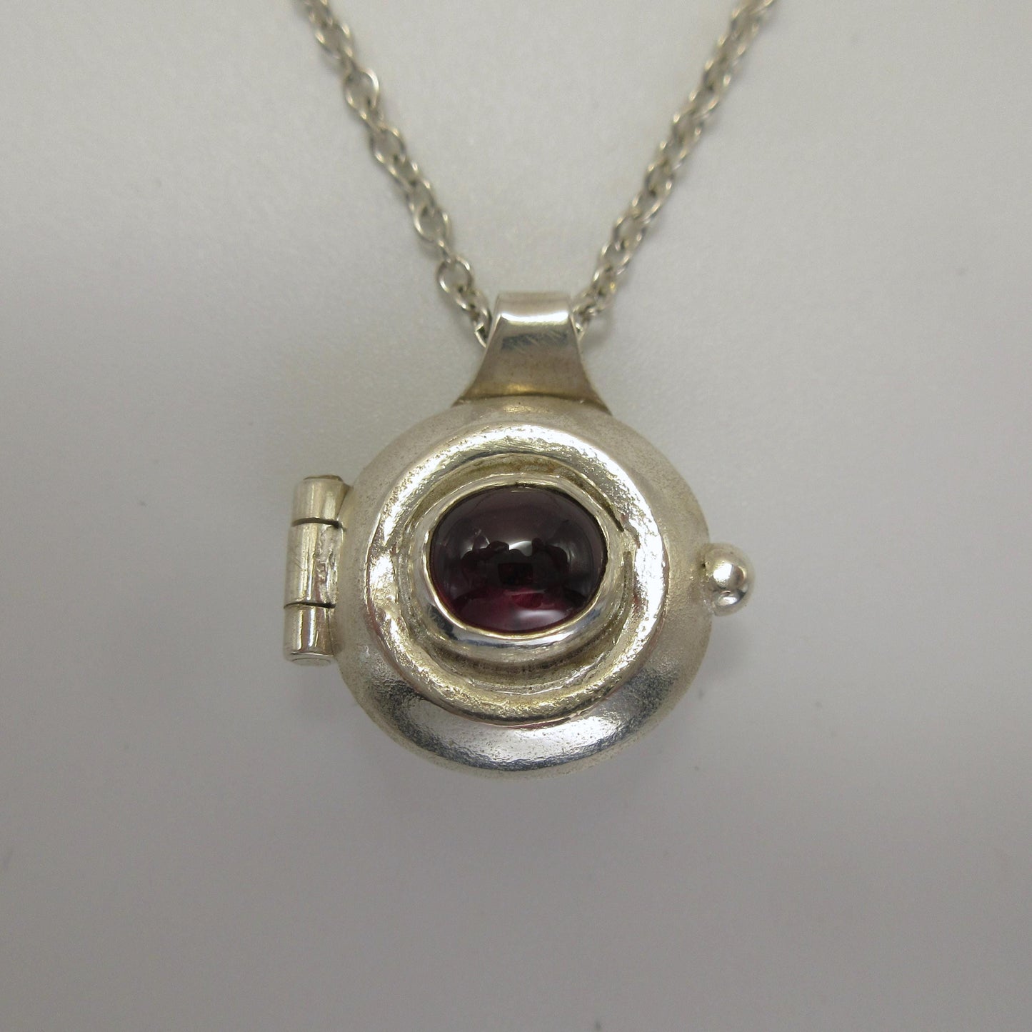 Garnet porthole locket in argentium sterling silver