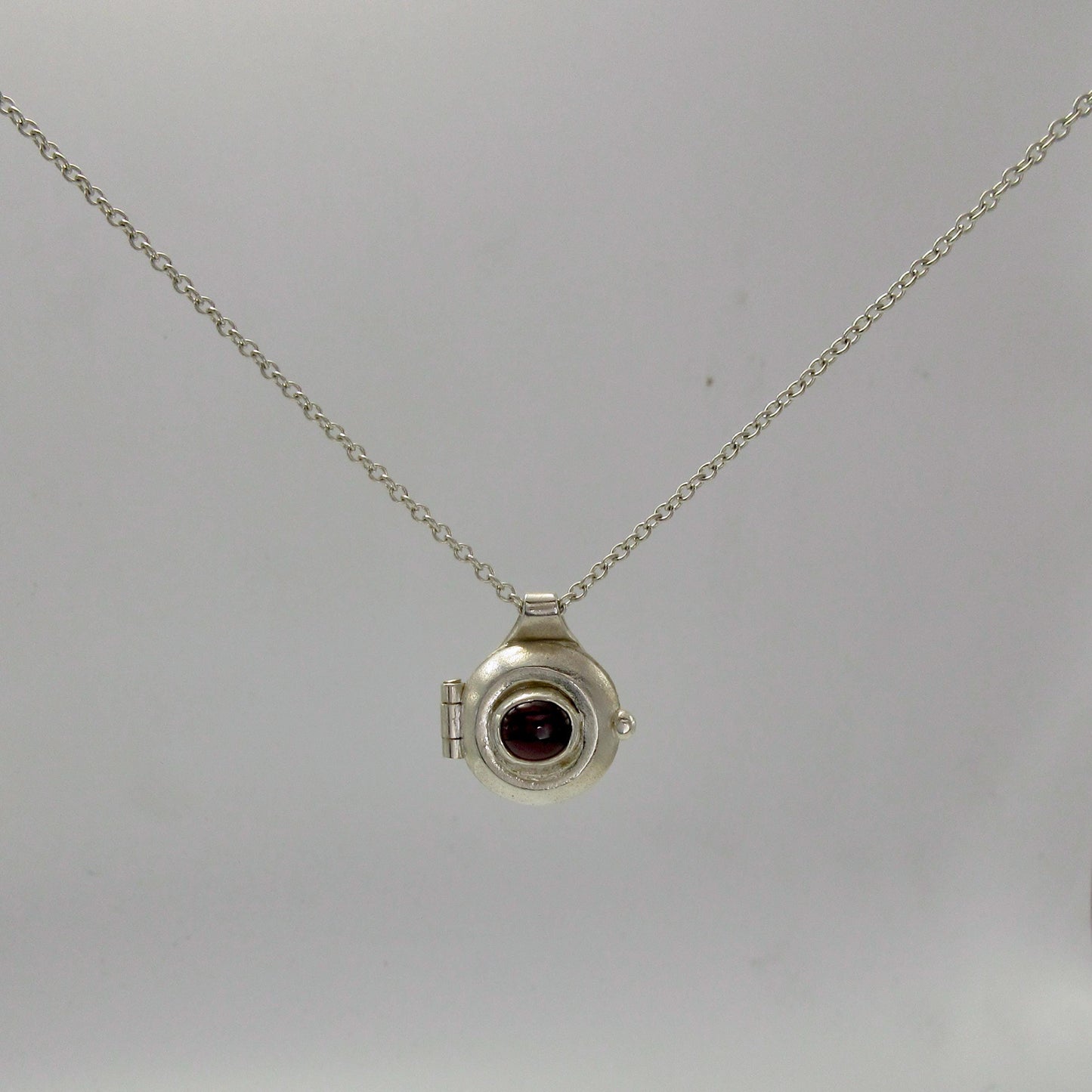 Garnet porthole locket in argentium sterling silver